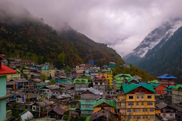 Wide landscape view of Lachen village in North Sikkim with traditional Himalayan architecture and a misty mountain backdrop.
