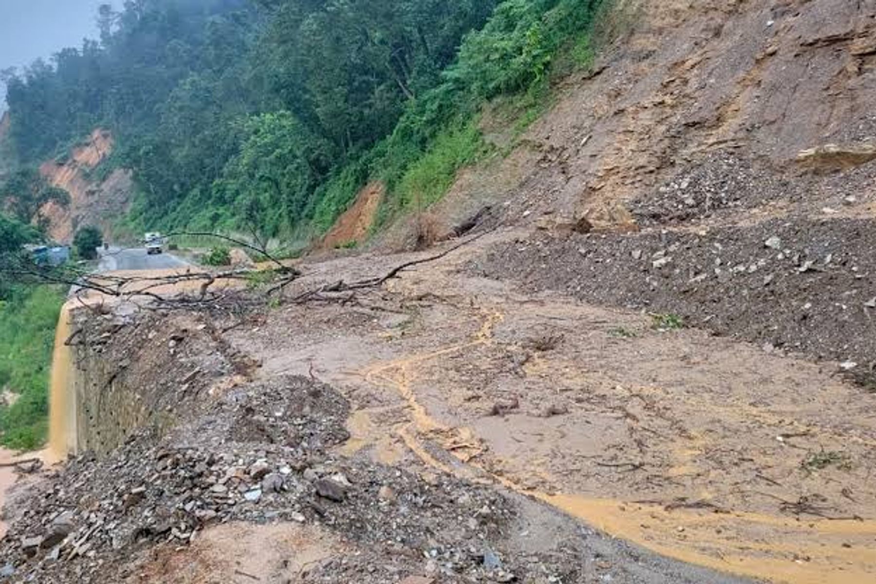 Vehicles on a wet Himalayan road during monsoon conditions