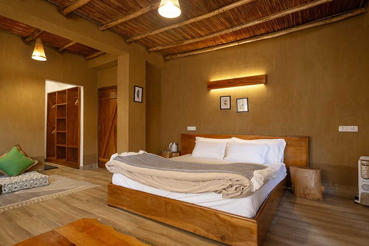 The interior of a cozy, modern Monpa-style wooden homestay in Tawang with a traditional heating stove.