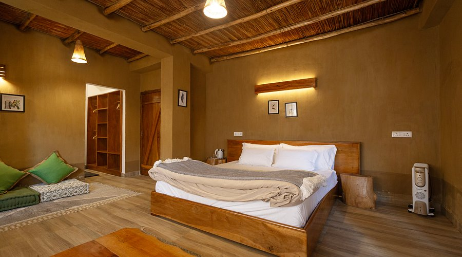 The interior of a cozy, modern Monpa-style wooden homestay in Tawang with a traditional heating stove.