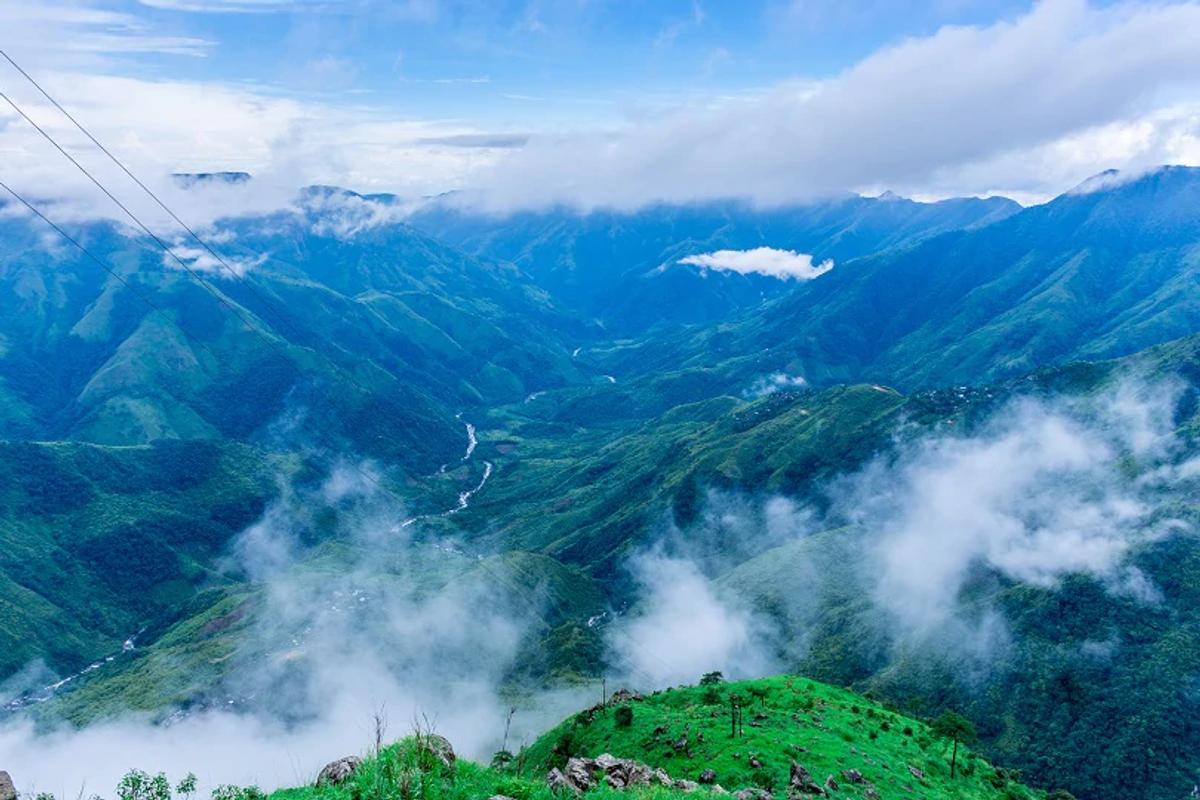 Massive green gorge at Laitlum Canyons with white mist covering the deep valley below.