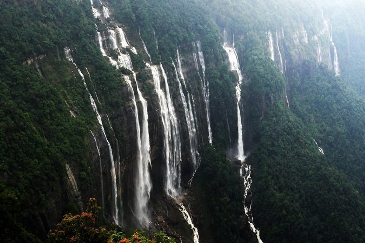 Seven Sisters Waterfall in Meghalaya during post-monsoon season with lush green surroundings