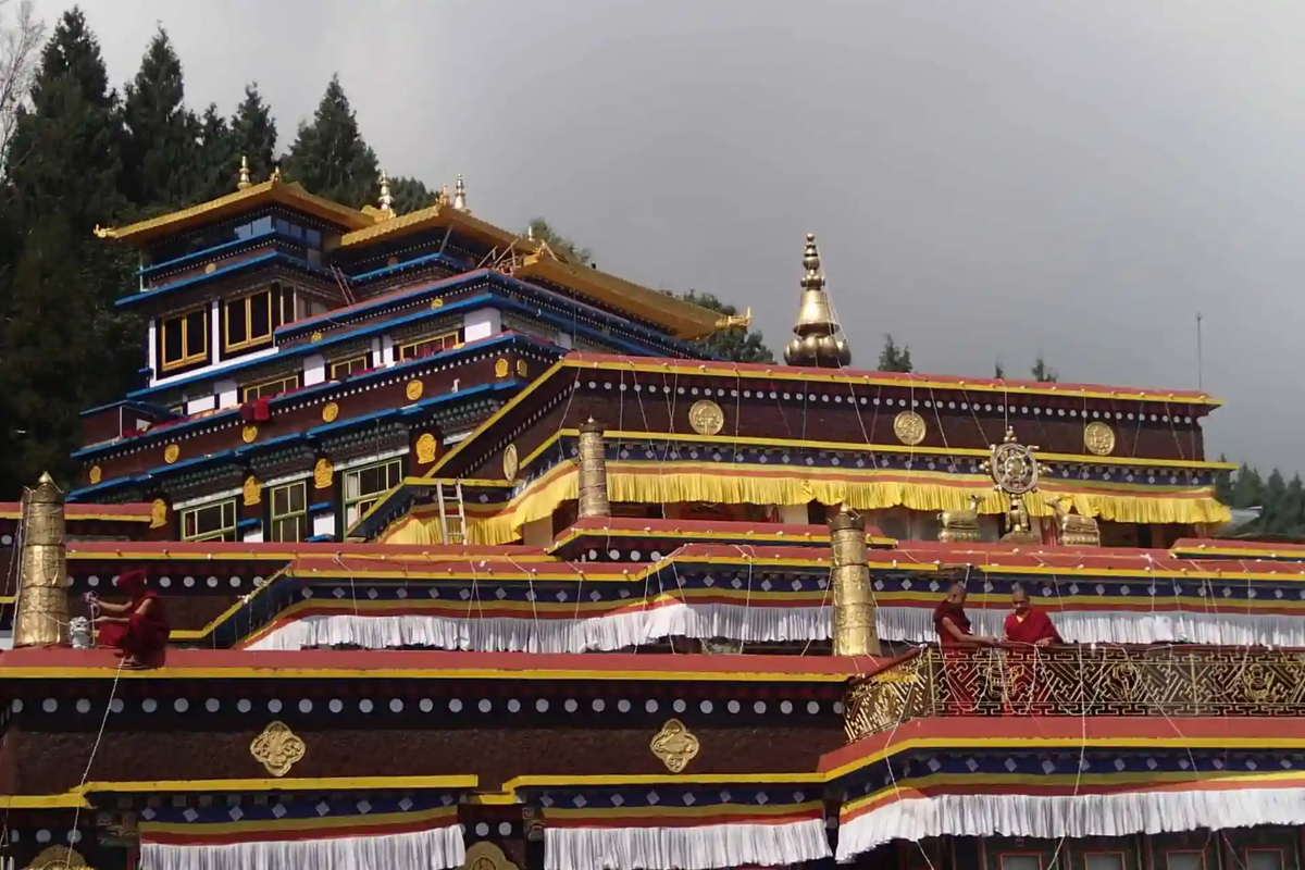 The main temple courtyard of Rumtek Monastery in East Sikkim, showcasing traditional Tibetan architecture with vibrant red and gold hand-painted pillars.