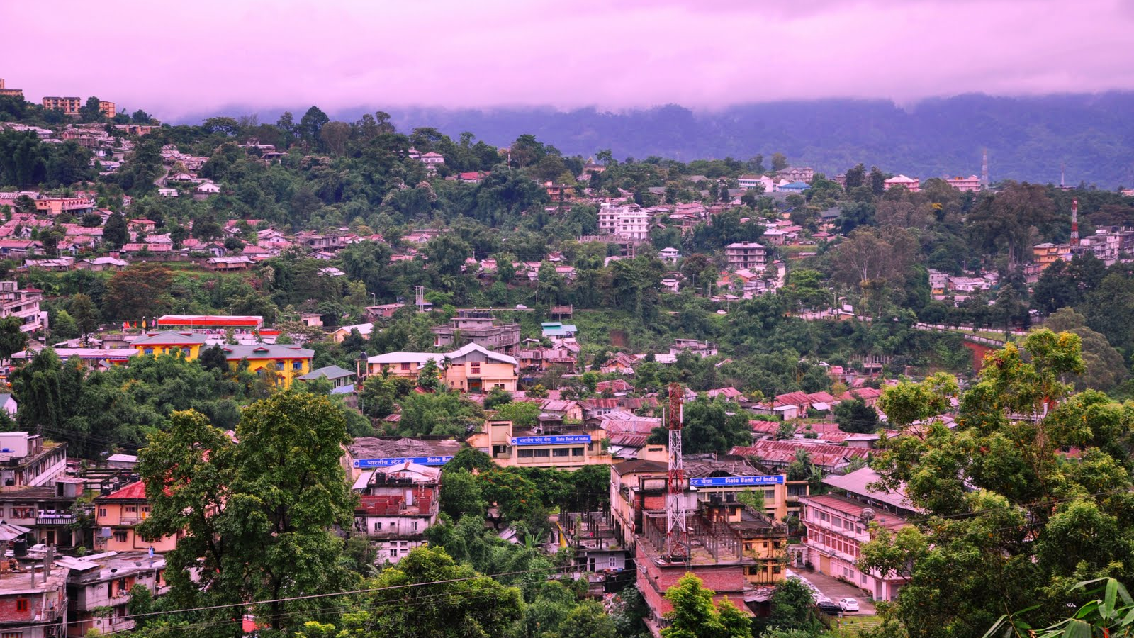 Panoramic aerial view of Itanagar city Arunachal Pradesh with rolling green hills and misty Himalayan foothills.