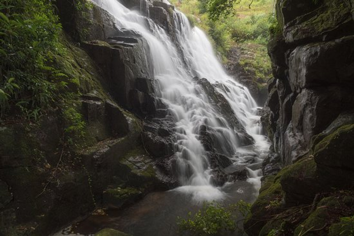 Stepped Tyrshi Falls in Jowai Jaintia Hills overlooking emerald green paddy fields.