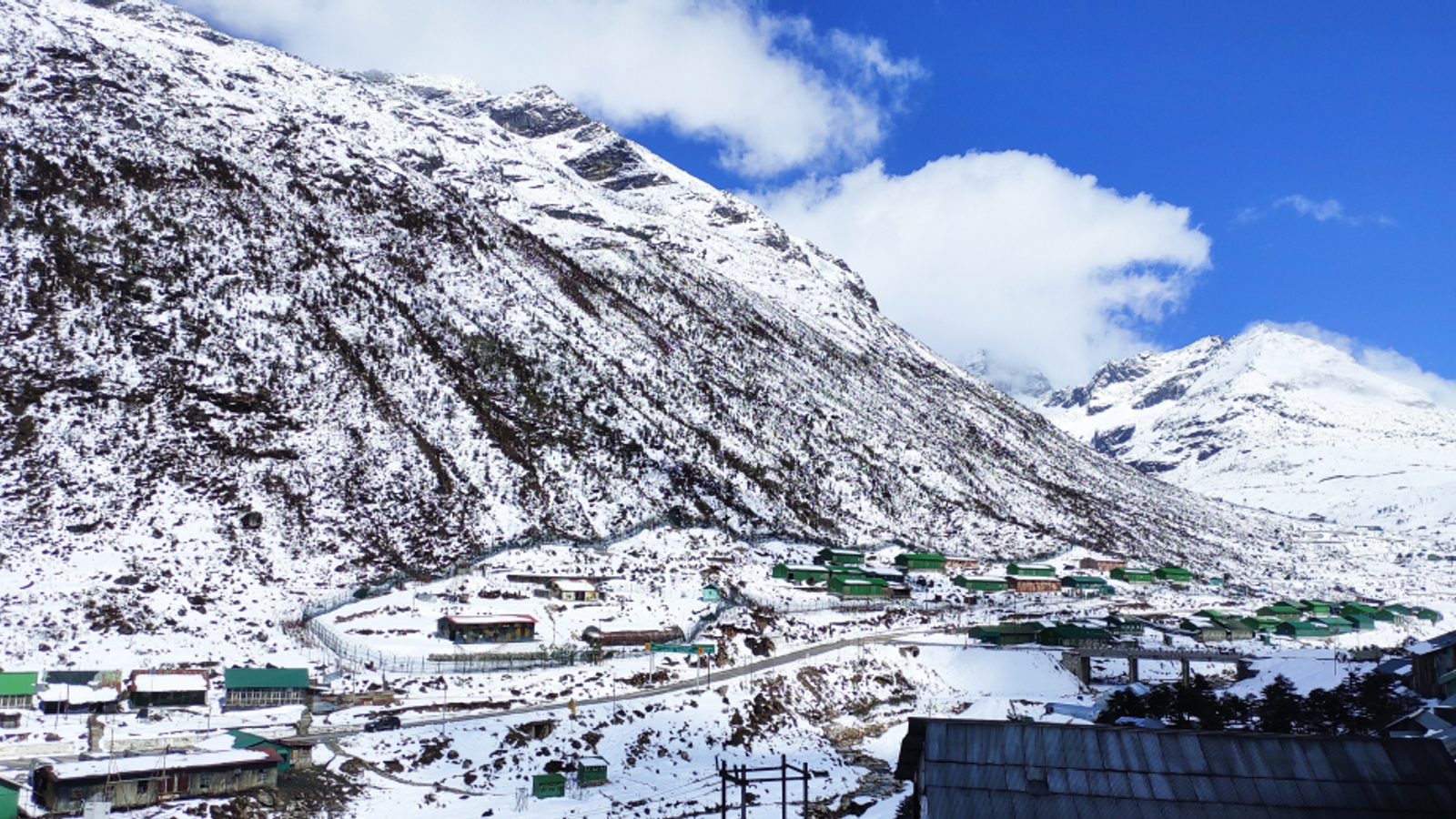 Snow-capped Himalayan peaks under a blue sky on the Twang road.