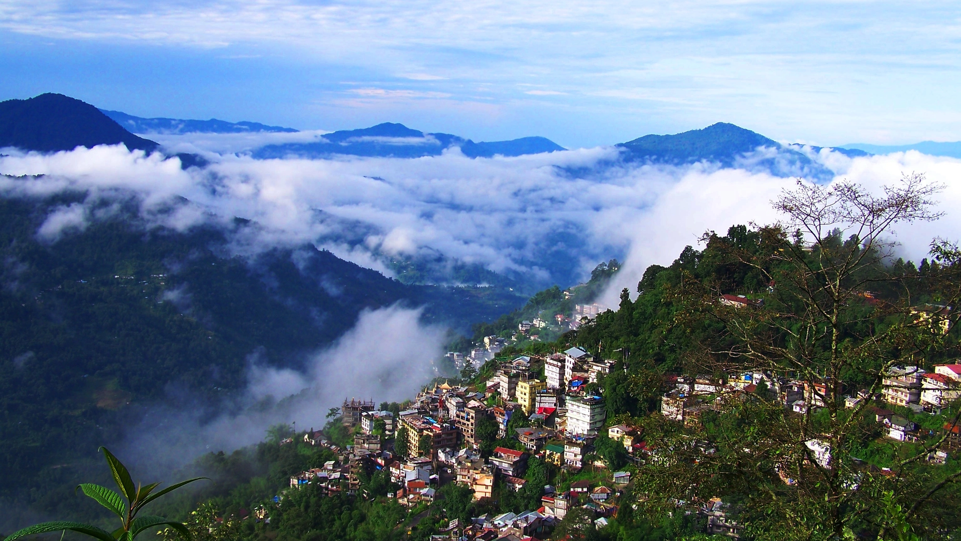 Gangtok city in Sikkim with colorful hillside buildings, Buddhist monasteries and views of Kangchenjunga in the Himalayas.