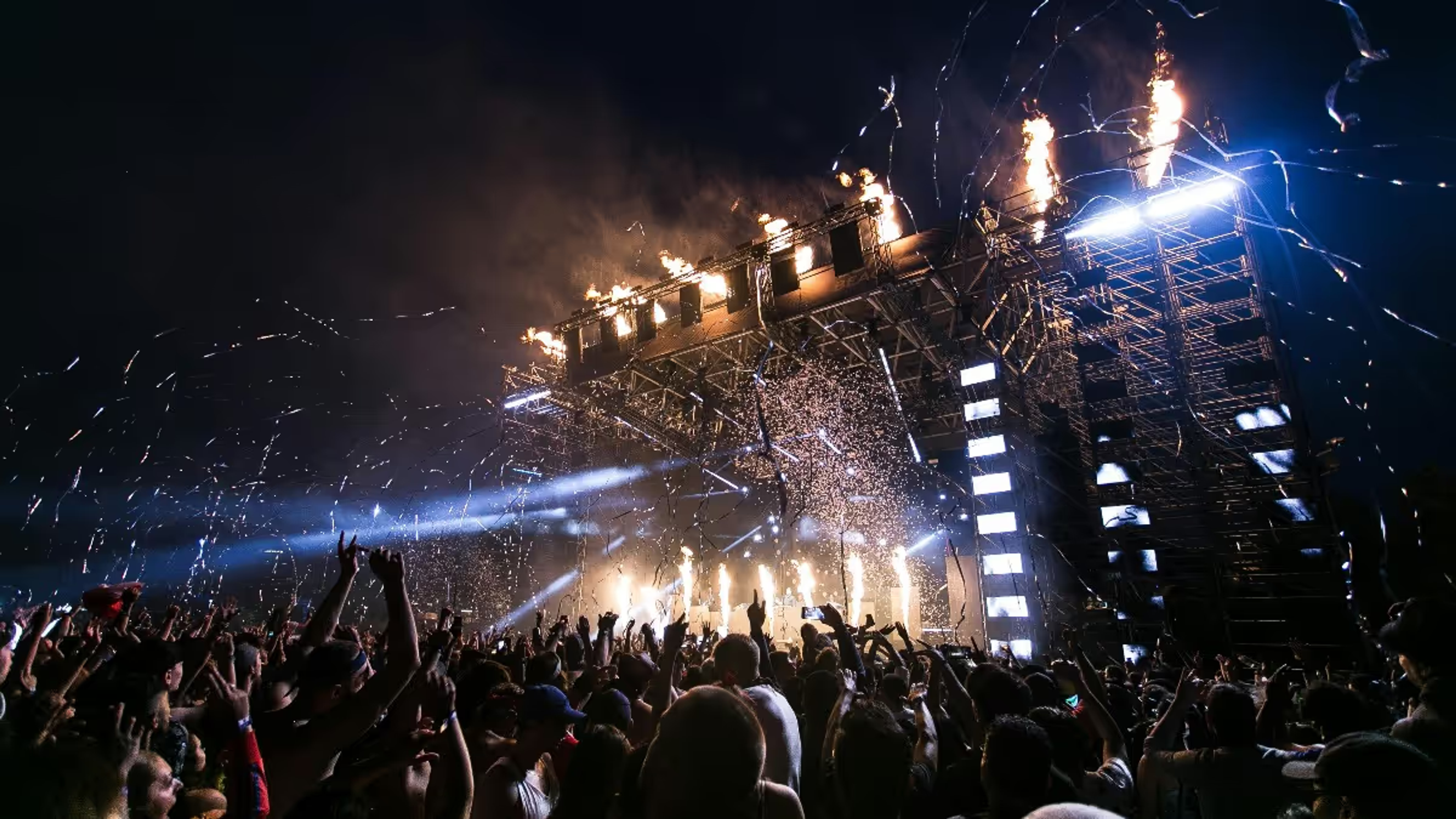 Festival crowd facing a lit main stage at night at the Shillong Cherry Blossom Festival