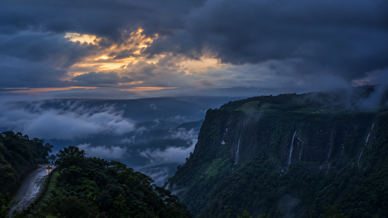 Cinematic twilight view of the Cherrapunji plateau under heavy monsoon clouds and thick mist, showcasing the atmospheric beauty of the region."