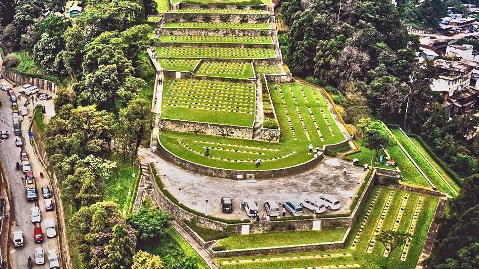 Kohima War Cemetery in Nagaland with rows of white gravestones and gardens set against the green hills of Northeast India.