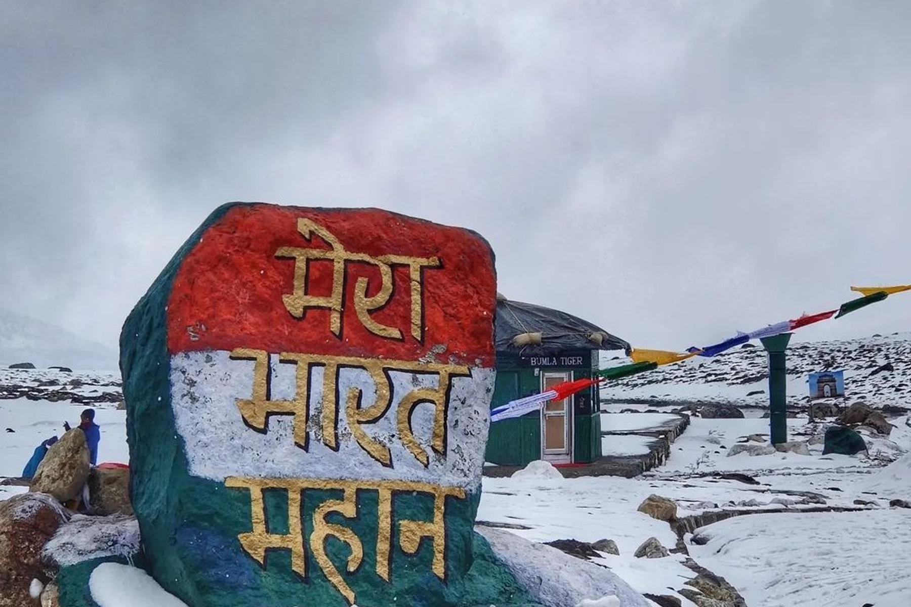 Snow-covered road and army signboard at Bumla Pass near Tawang