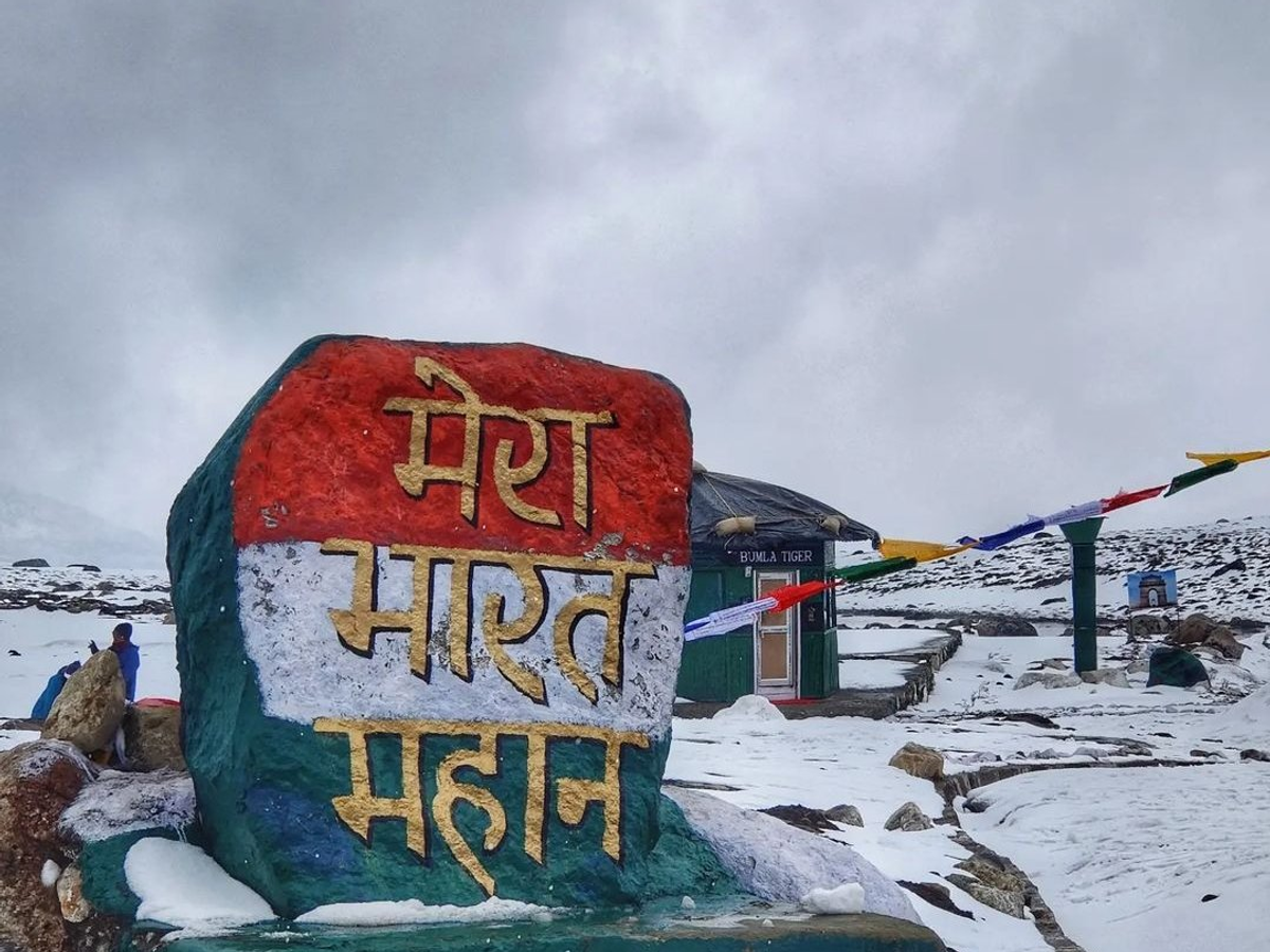 Snow-covered road and army signboard at Bumla Pass near Tawang