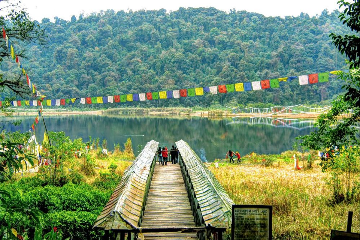 The sacred Khecheopalri Lake surrounded by prayer flags, a unique wishing lake and pilgrimage site in West Sikkim.