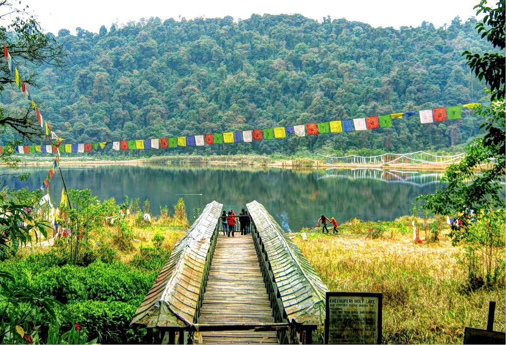 The sacred Khecheopalri Lake surrounded by prayer flags, a unique wishing lake and pilgrimage site in West Sikkim.