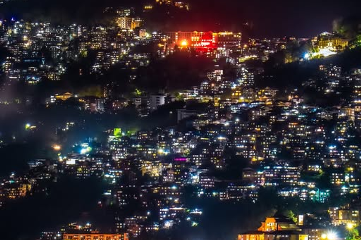 A panoramic night view of Gangtok city lights on a mountain slope in East Sikkim.