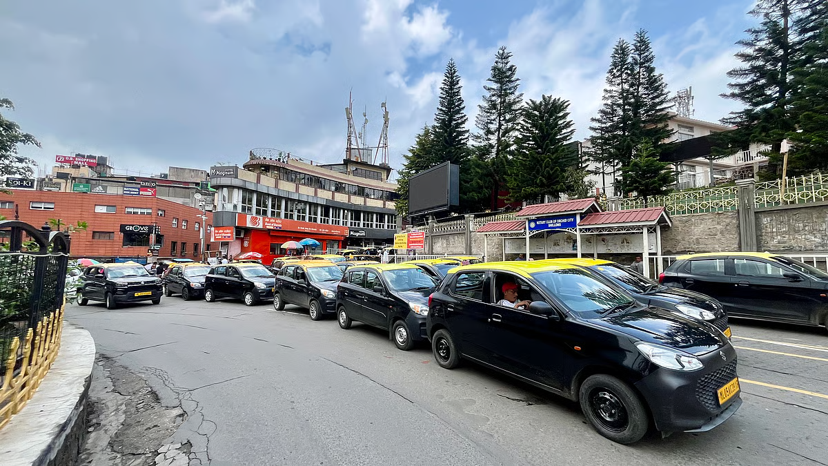 A yellow local taxi parked on a misty road in Shillong.