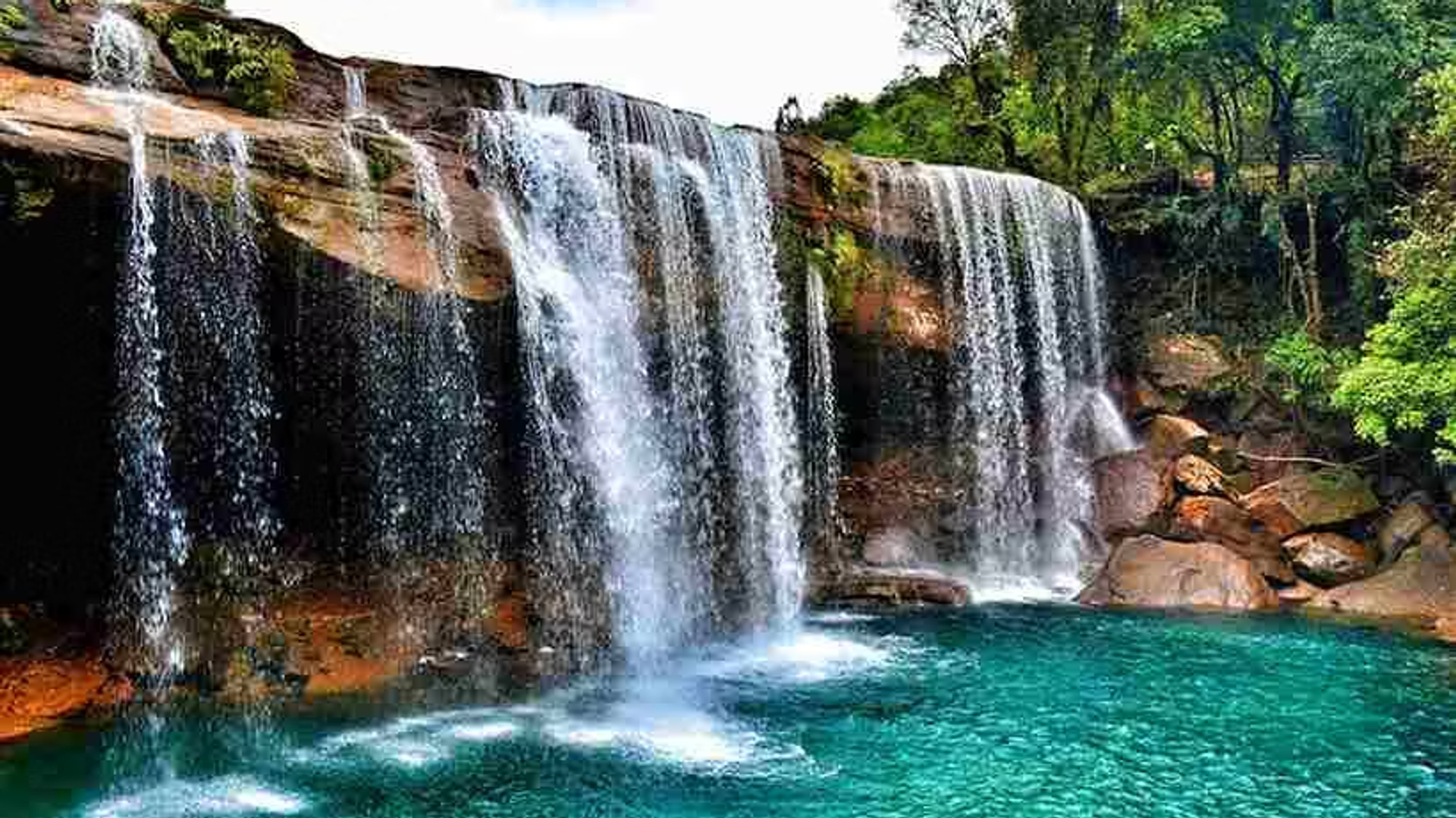 Krang Suri Falls in Jowai, Meghalaya with turquoise water surrounded by lush forest in the scenic Jaintia Hills.