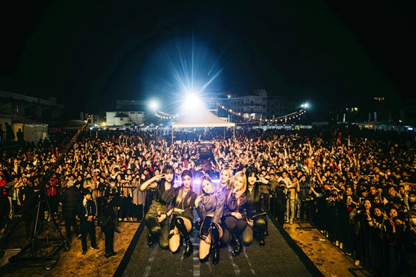 Crowd facing the main stage at the Shillong Cherry Blossom Festival at night with stage lights