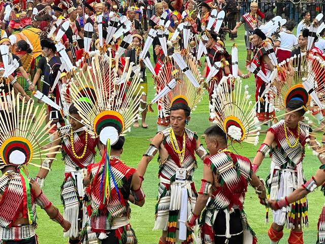 Naga dancers in traditional warrior dress performing in the arena at the Hornbill Festival in Kisama, Nagaland
