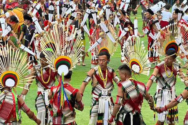Naga dancers in traditional warrior dress performing in the arena at the Hornbill Festival in Kisama, Nagaland