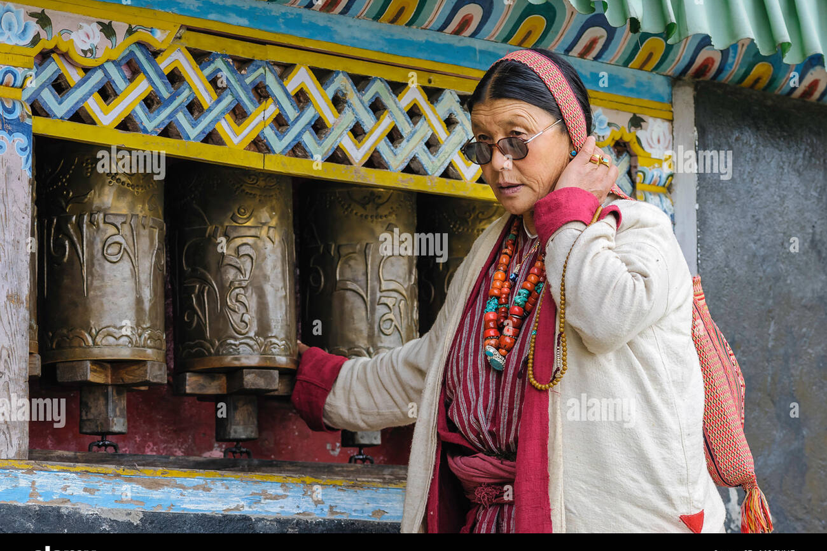 : A traditional Monpa man spinning a prayer wheel, representing the spiritual culture of Tawang, Arunachal Pradesh.