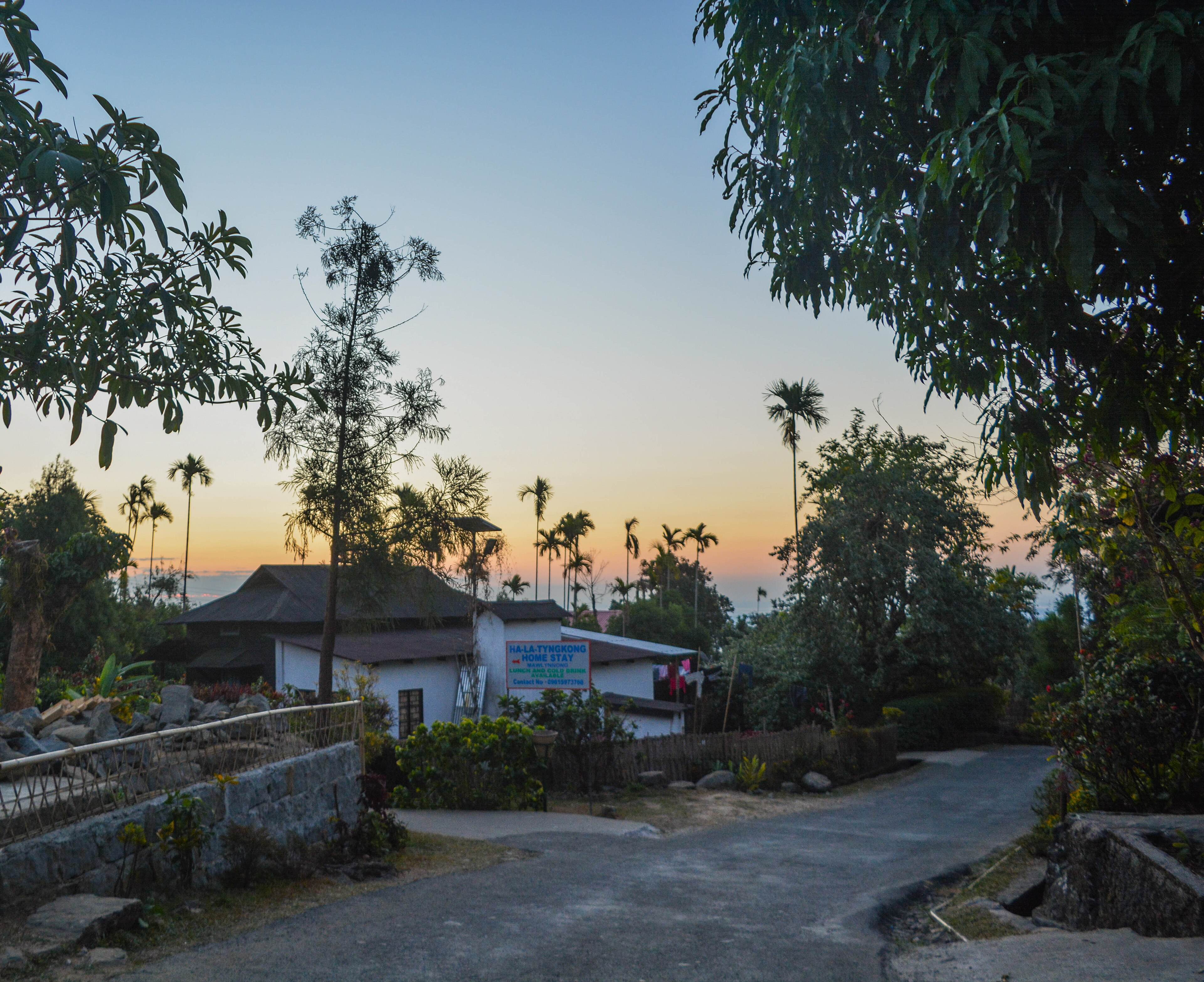 A clean lane through Mawlynnong village at sunset