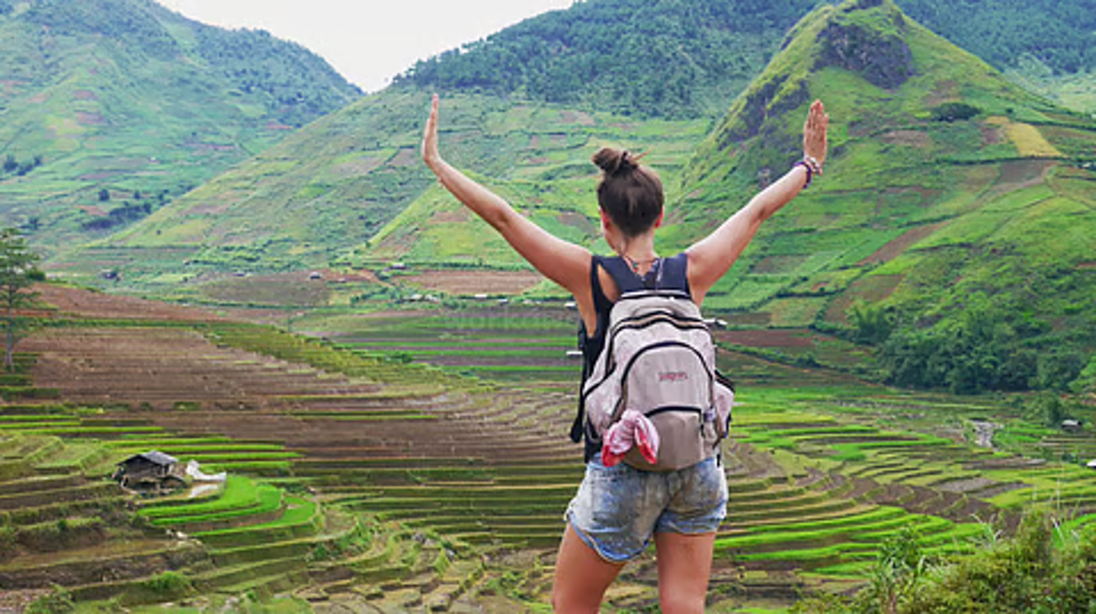 A solo female traveler safely exploring the scenic valleys of Arunachal Pradesh, illustrating the state's travel safety for women.