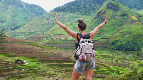 A solo female traveler safely exploring the scenic valleys of Arunachal Pradesh, illustrating the state's travel safety for women.
