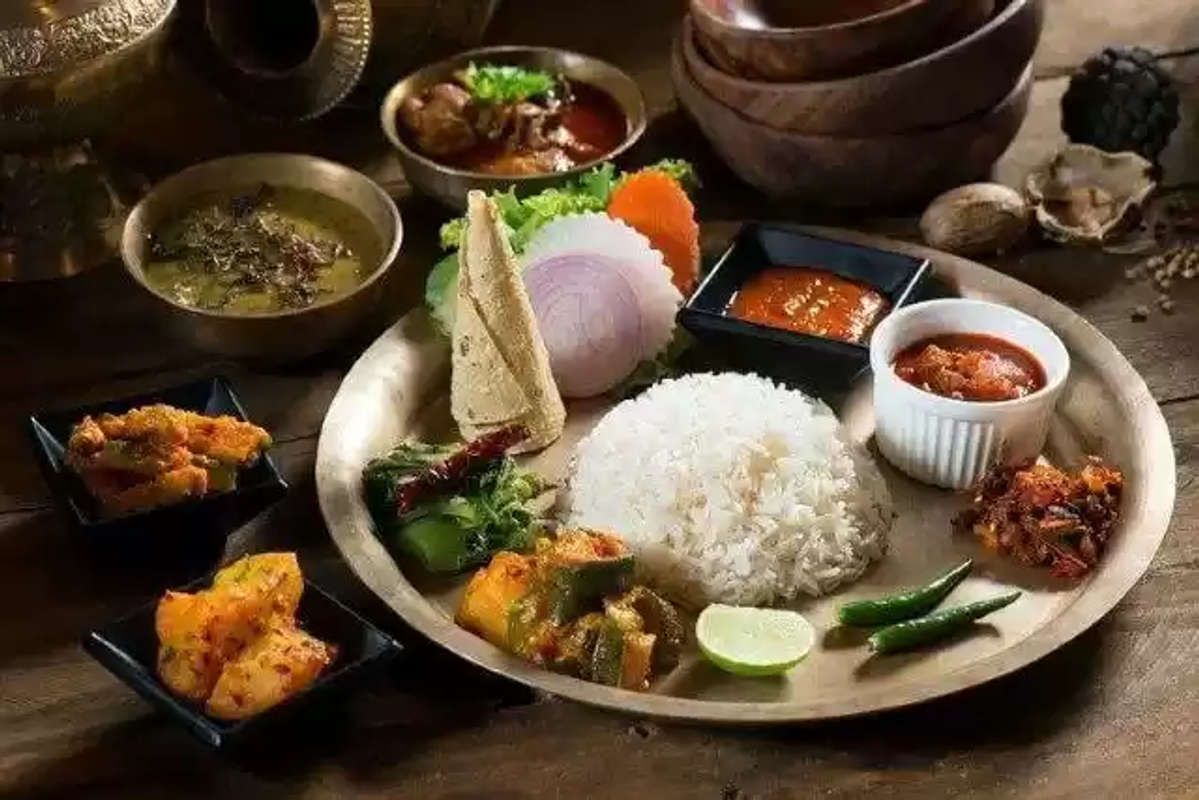 A traditional Sikkimese thali featuring organic red rice, gundruk, lentils, and yak cheese curry on a brass plate