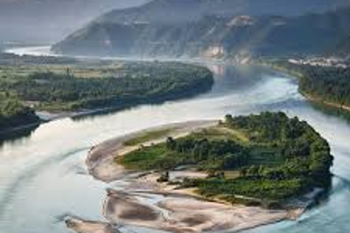 An aerial view of the Siang River confluence in Pasighat, Arunachal Pradesh, during a clear summer day.