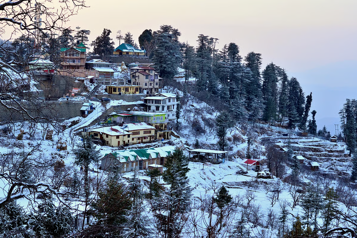Aerial view of Tawang town and surrounding Himalayan mountains covered in thick white winter snow during January
