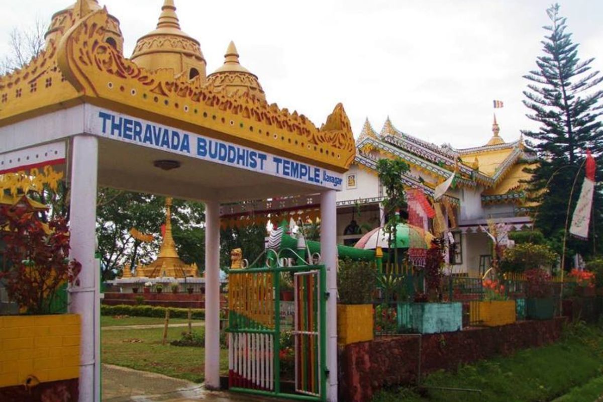 Yellow-roofed Theravada Buddhist Temple in Itanagar at sunset with a golden stupa and Himalayan views.