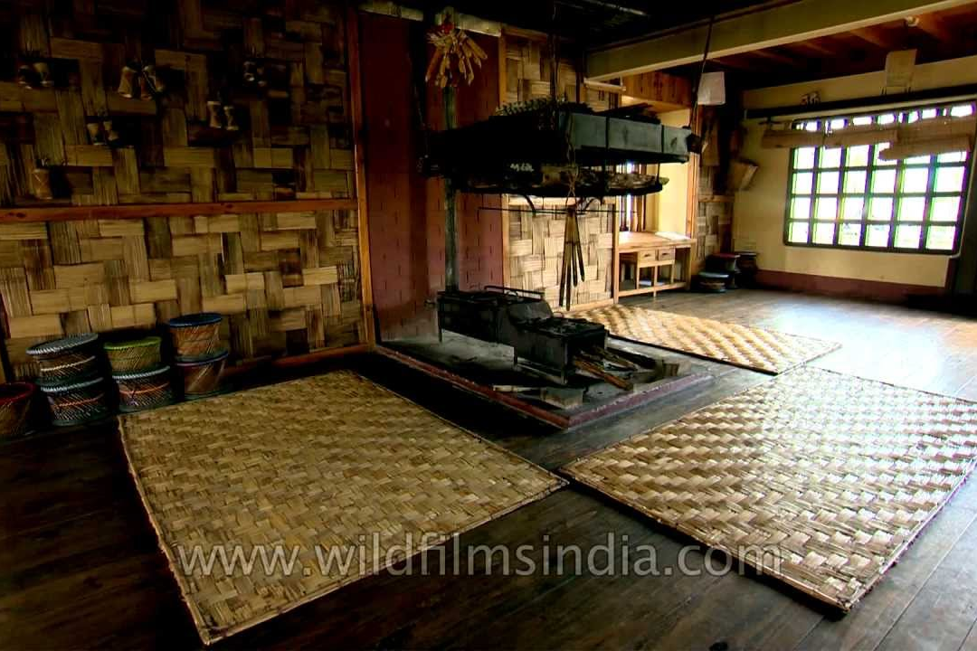 Interior of a traditional Apatani bamboo homestay in Ziro Valley, featuring a central hearth and authentic tribal decor."