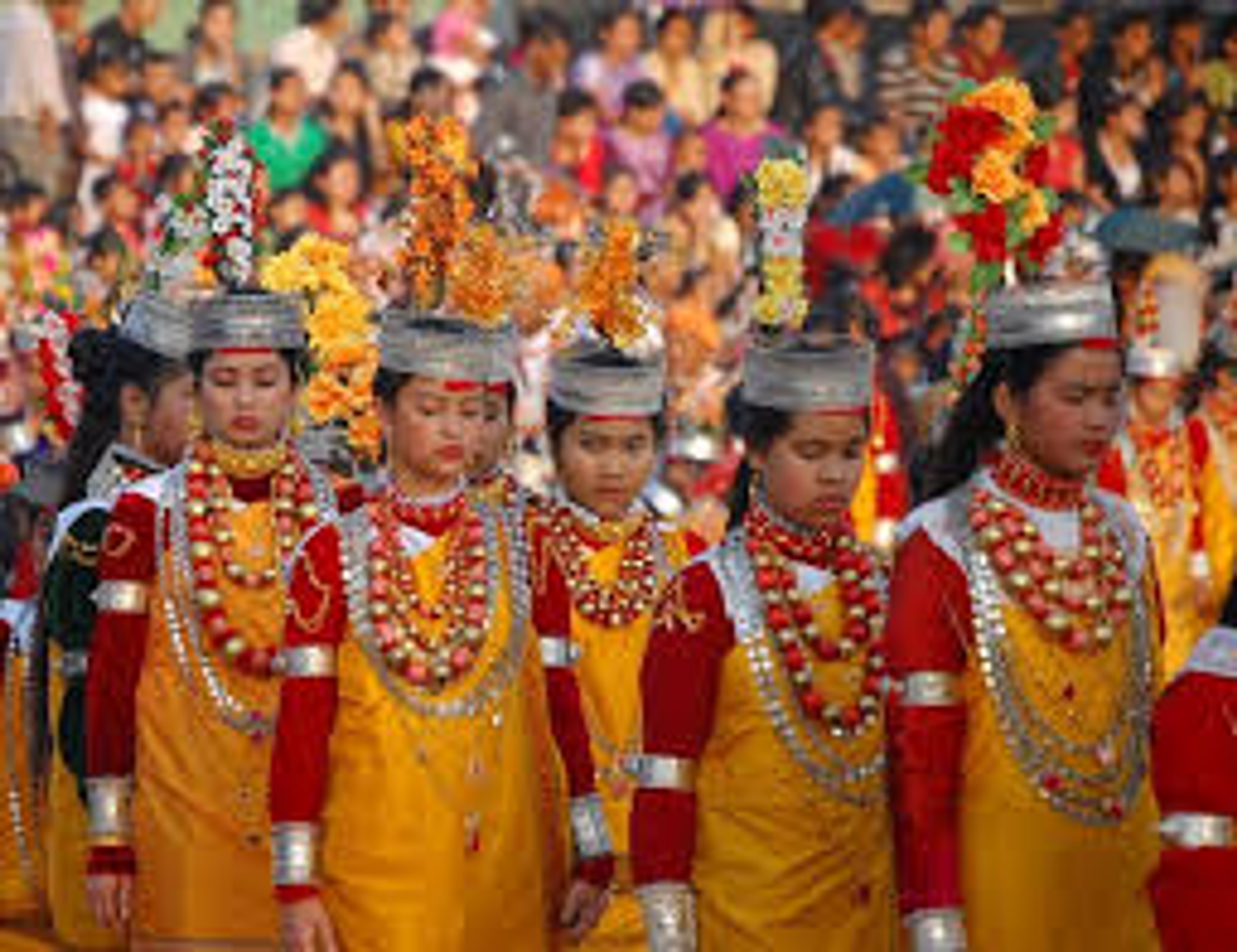 Khasi men and women performing traditional dance in colorful silk Jainsem and Dhara attire during Nongkrem Festival.]