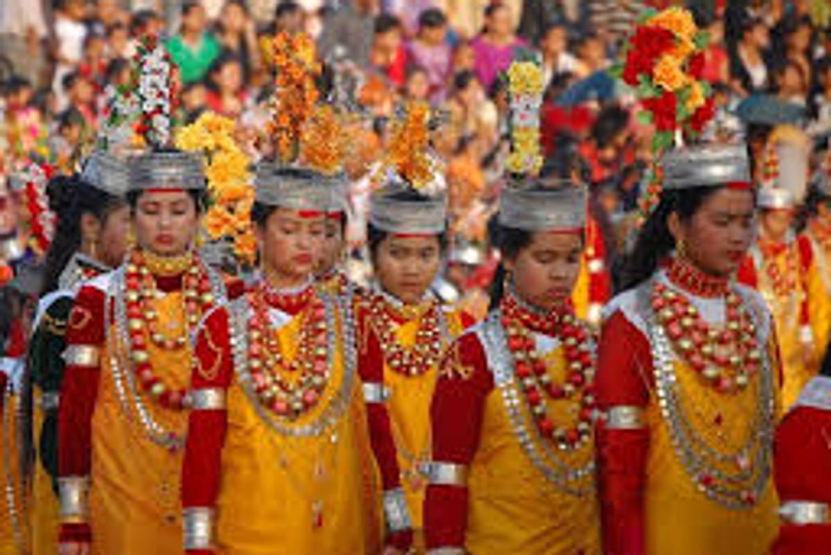 Khasi men and women performing traditional dance in colorful silk Jainsem and Dhara attire during Nongkrem Festival.]