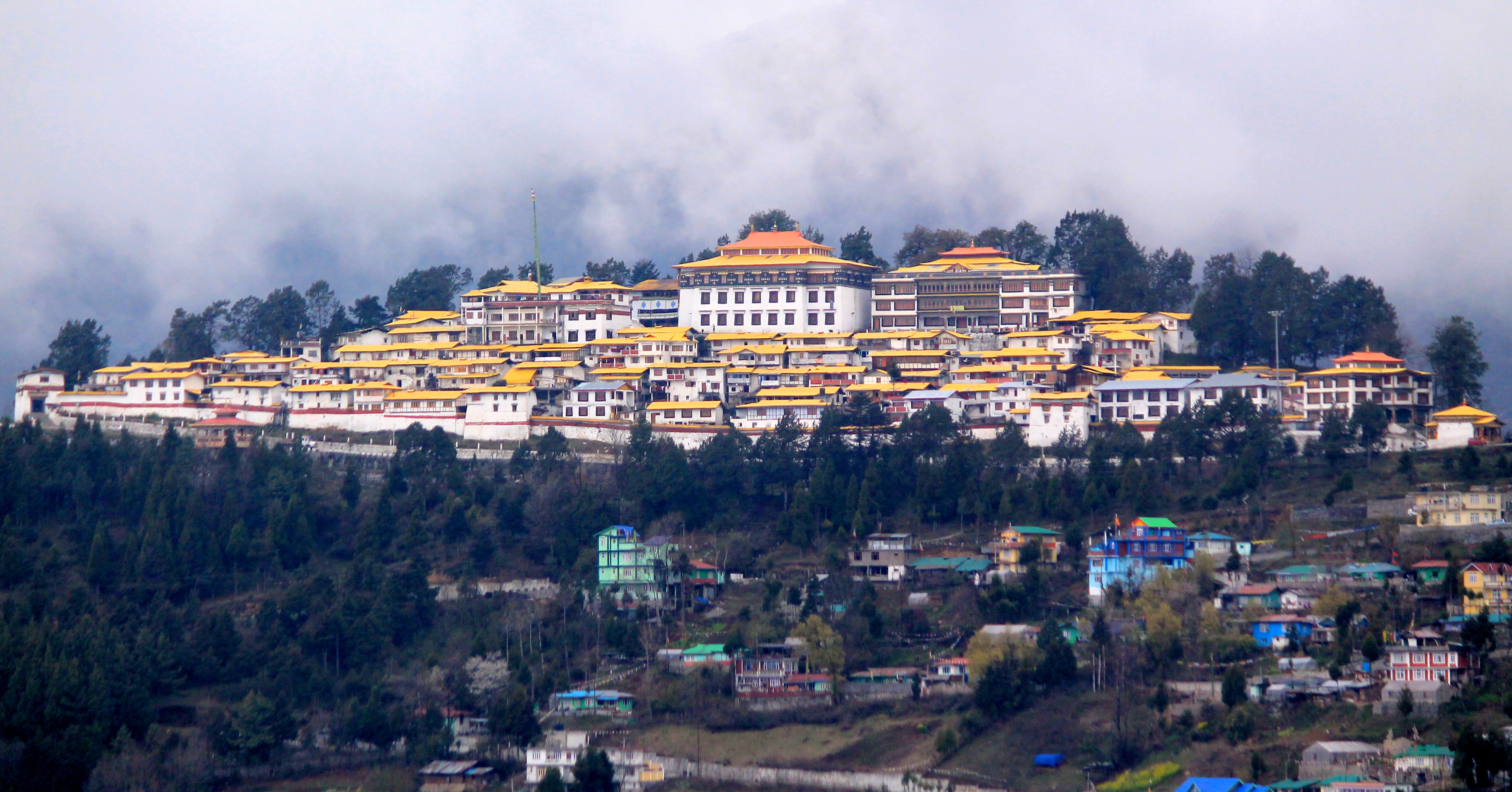 ''Wide view of Tawang Monastery on a mountain ride under sky.''