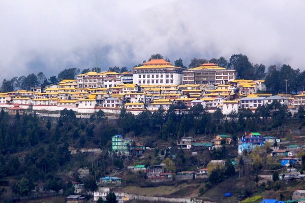 ''Wide view of Tawang Monastery on a mountain ride under sky.''