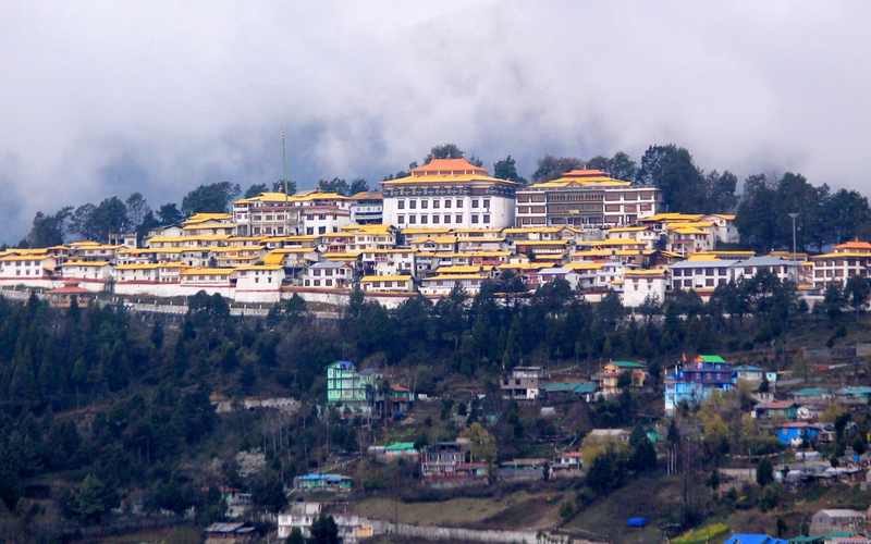 ''Wide view of Tawang Monastery on a mountain ride under sky.''