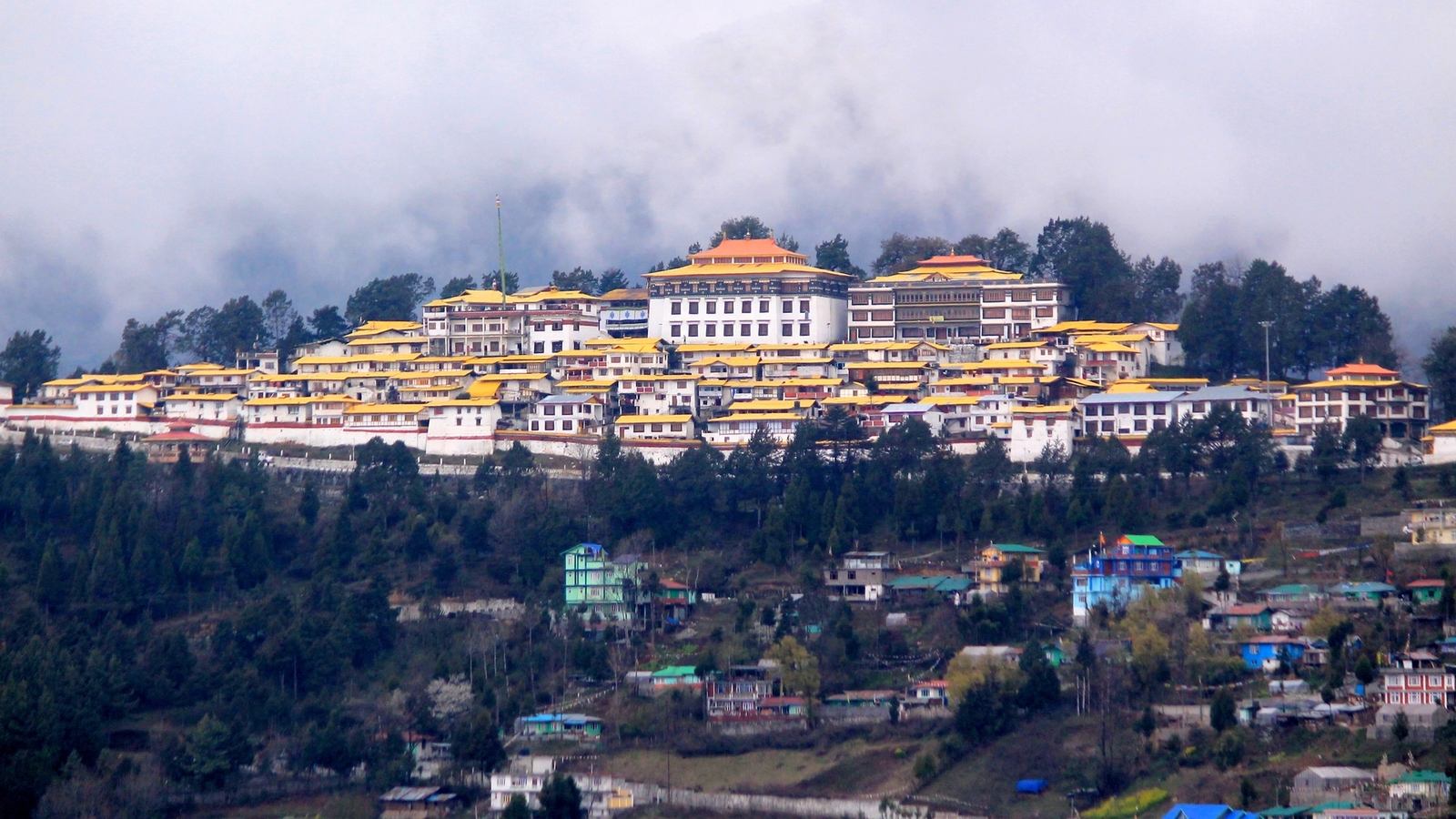 ''Wide view of Tawang Monastery on a mountain ride under sky.''