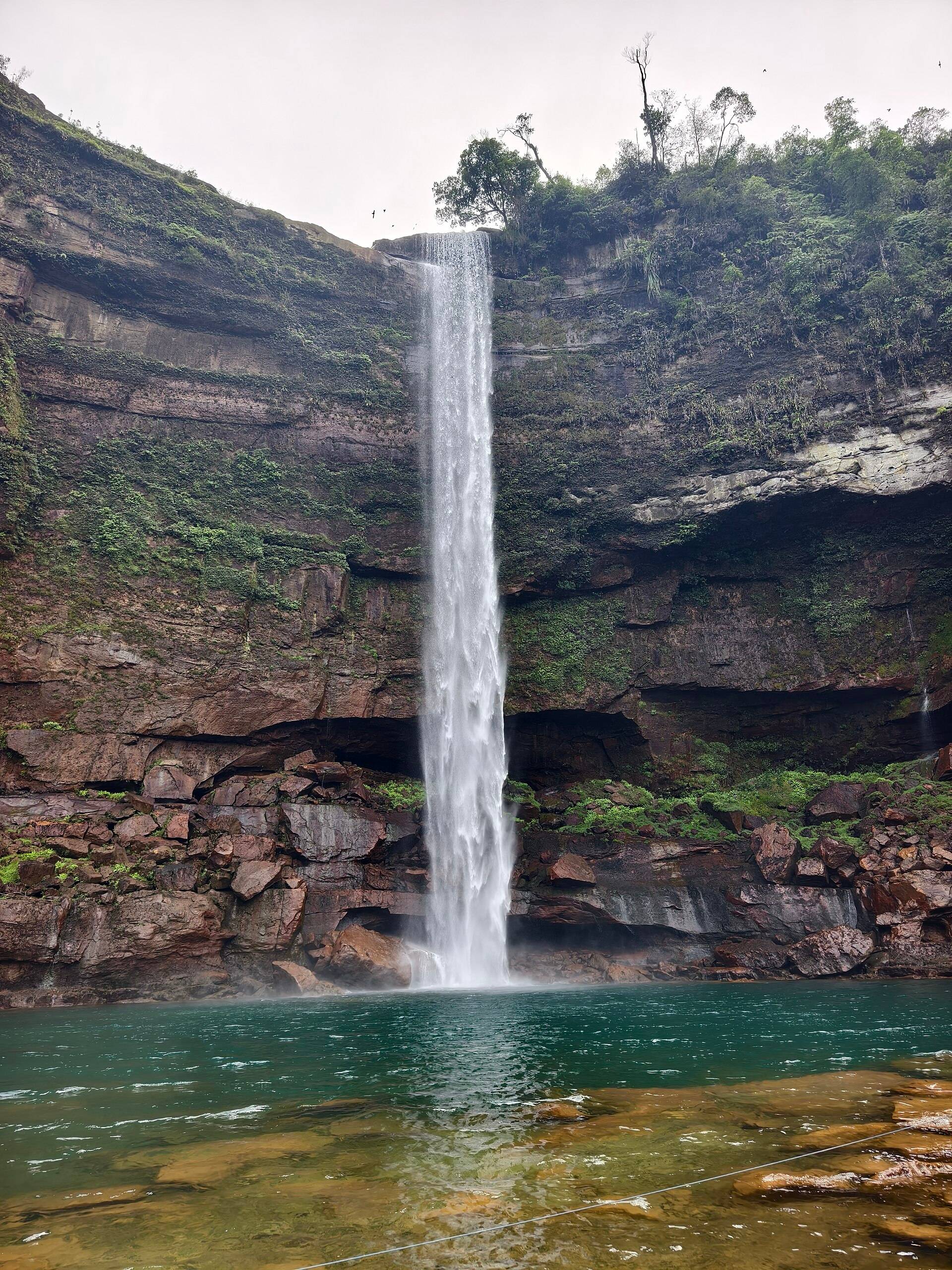Phe Phe waterfall falling into a turquoise pool in a rocky gorge near Jowai