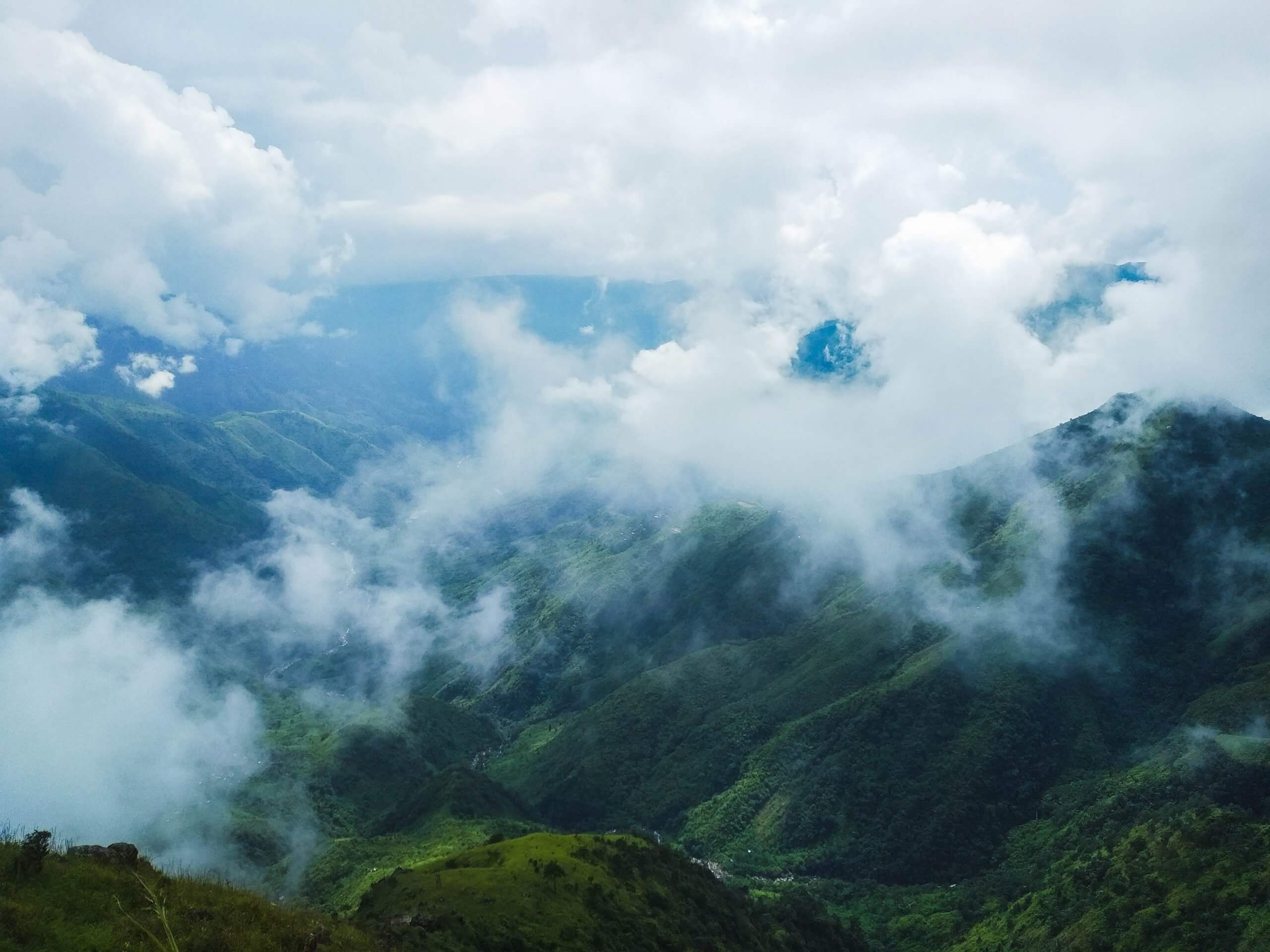 A breathtaking aerial view of the emerald, green hills and misty clouds of Meghalaya, India.