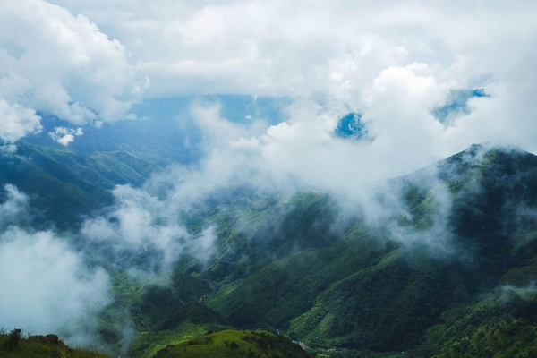 A breathtaking aerial view of the emerald, green hills and misty clouds of Meghalaya, India.