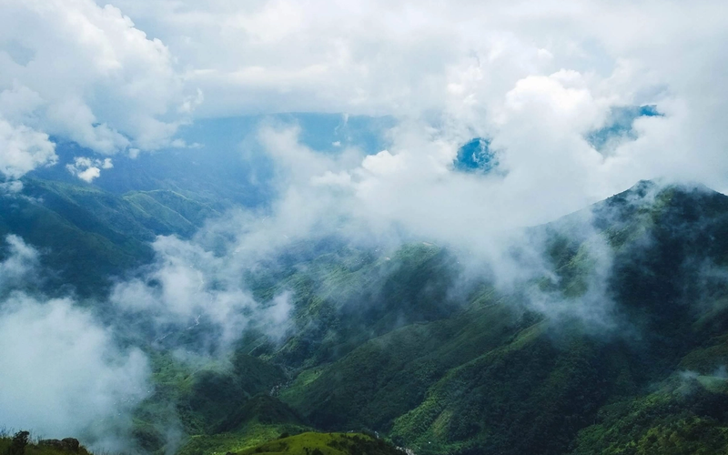 A breathtaking aerial view of the emerald, green hills and misty clouds of Meghalaya, India.