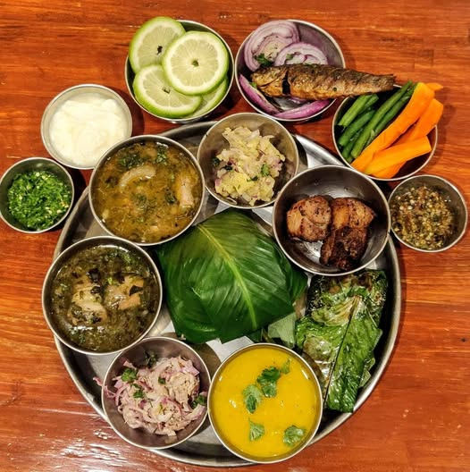 Traditional Apatani food platter with bamboo-shoot pork and rice beer served in a bamboo tumbler.