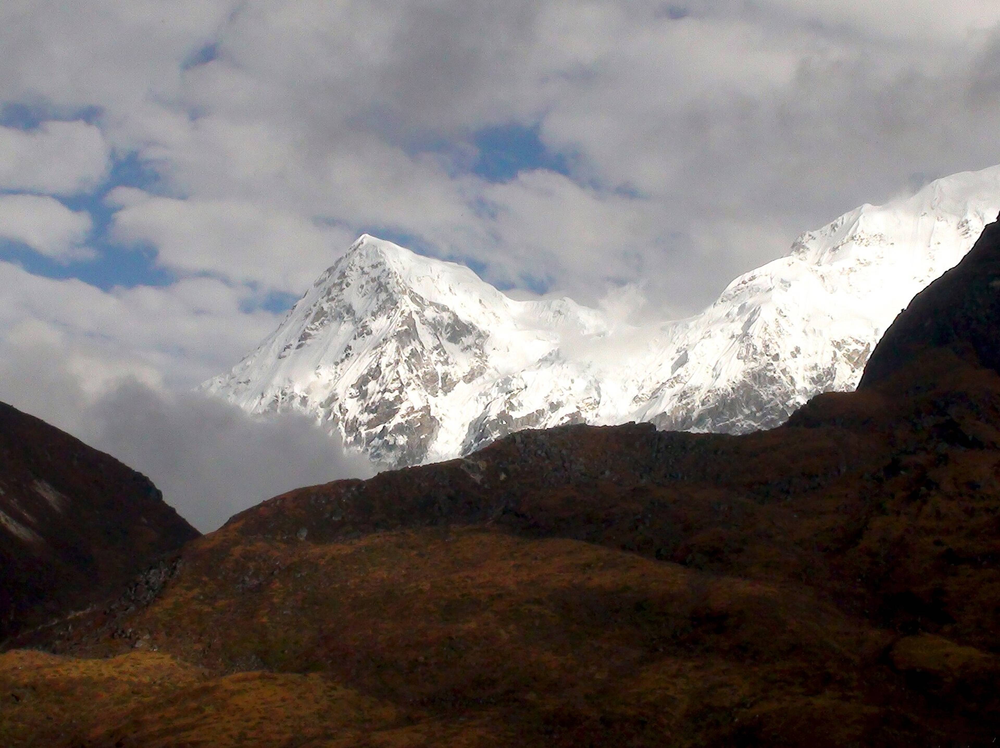 Snow-covered Mount Rathong rising above brown hills, seen from Dzongri in West Sikkim