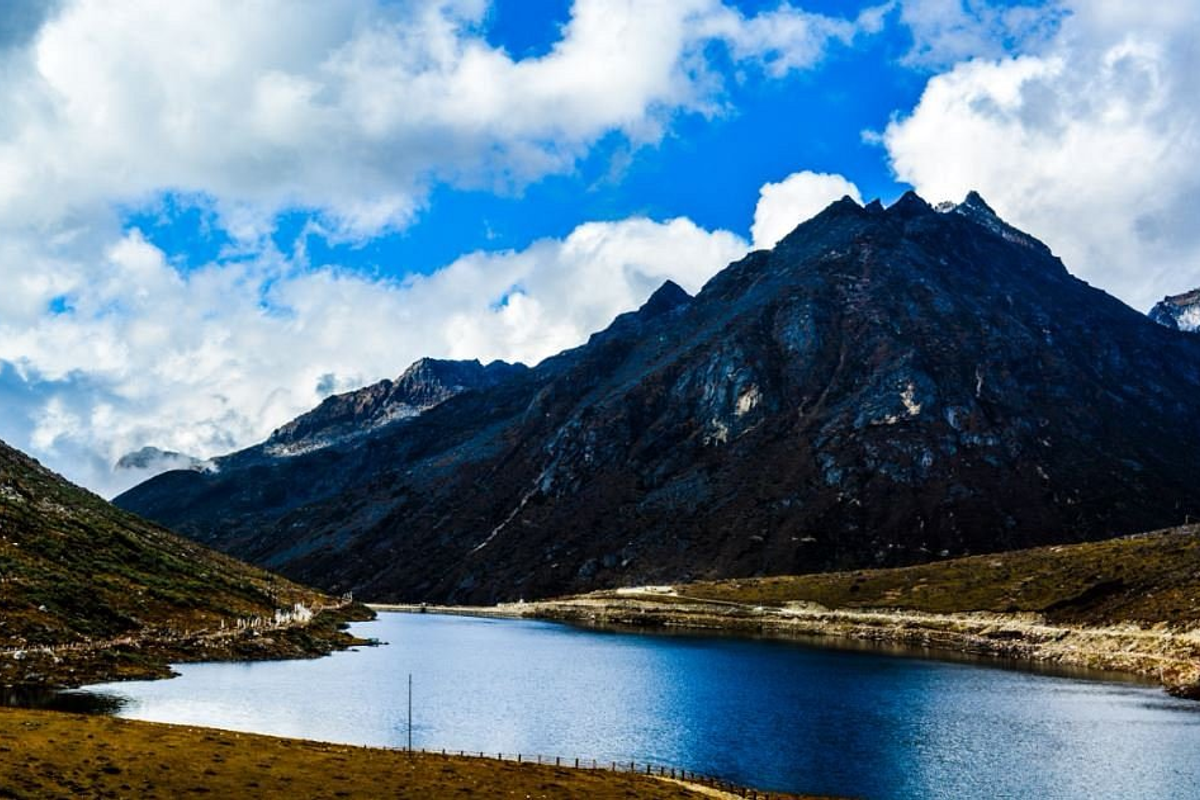 Frozen Sela Lake in Arunachal Pradesh surrounded by thick white snow and the Sela Pass gateway.