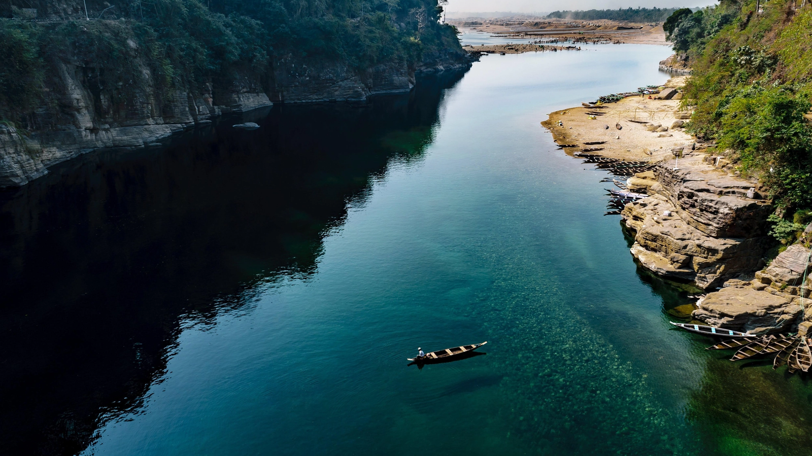 Crystal-clear Dawki River surrounded by hills in Meghalaya, India