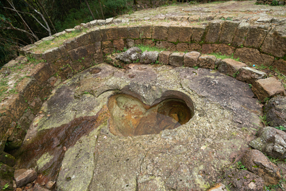 A small, heart-shaped pool naturally eroded into the stone floor of the garden.