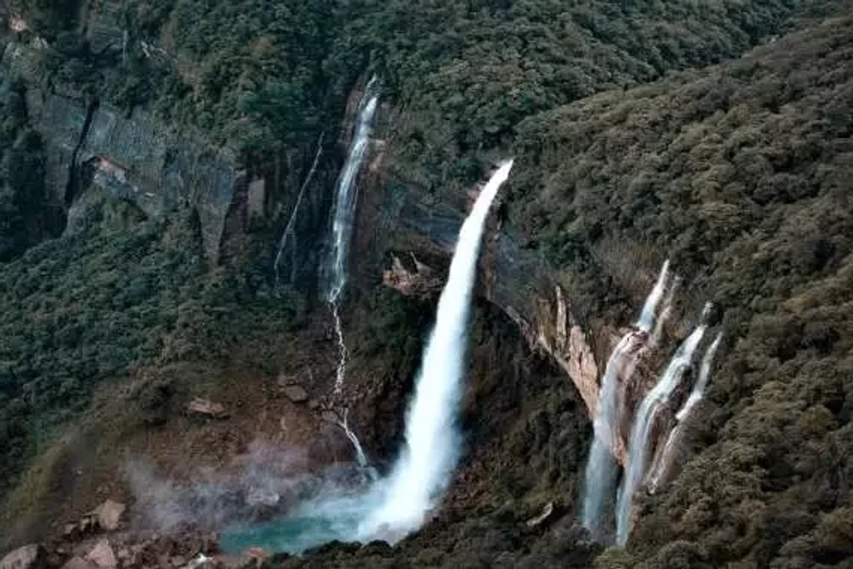 Tallest plunge waterfall in India Nohkalikai Falls crashing down a high limestone cliff into a green water pool below in Cherrapunji Meghalaya