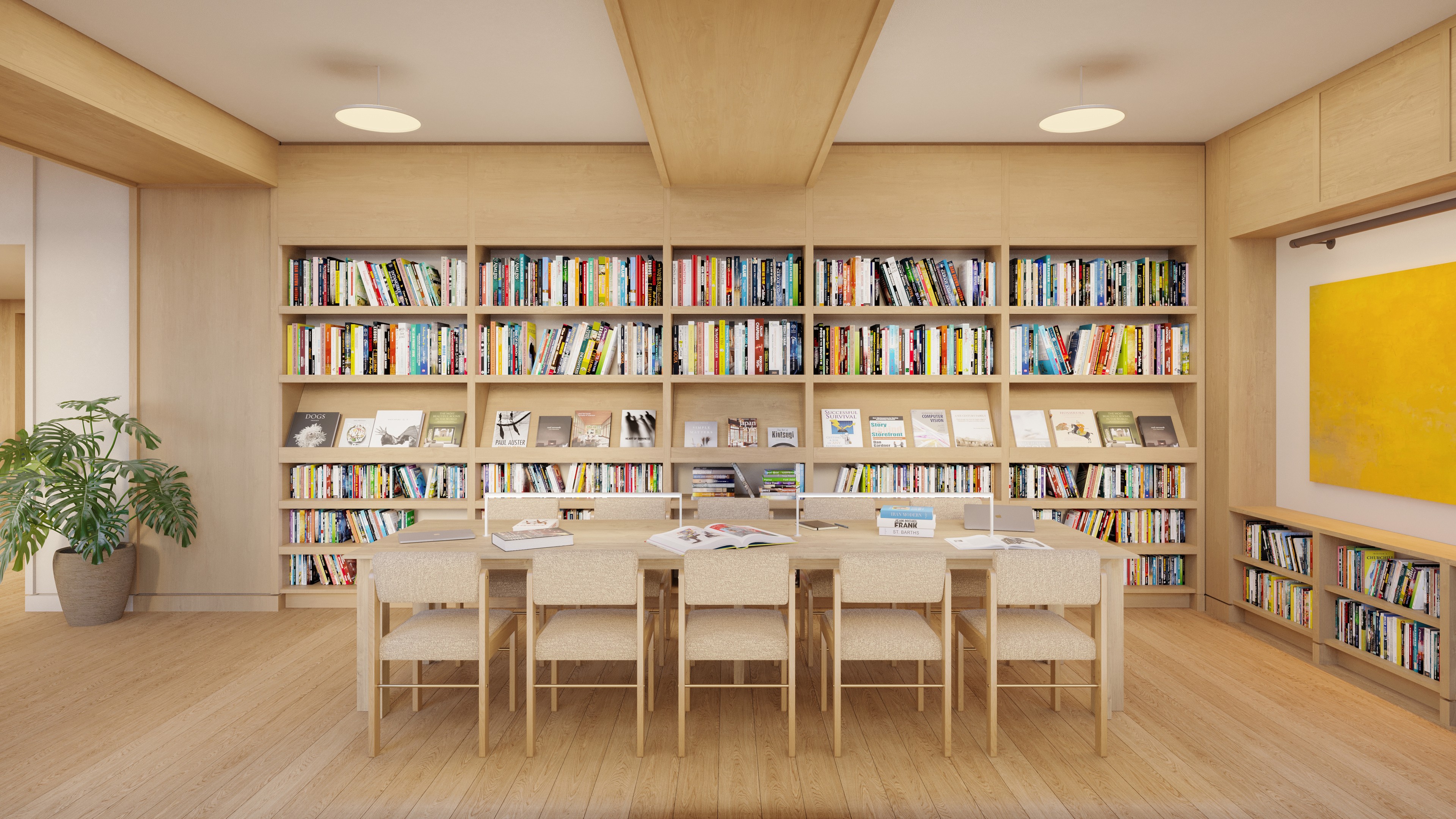 The Library at Ray Harlem featuring a large table, comfortable seating, and books curated by Phaidon Press.